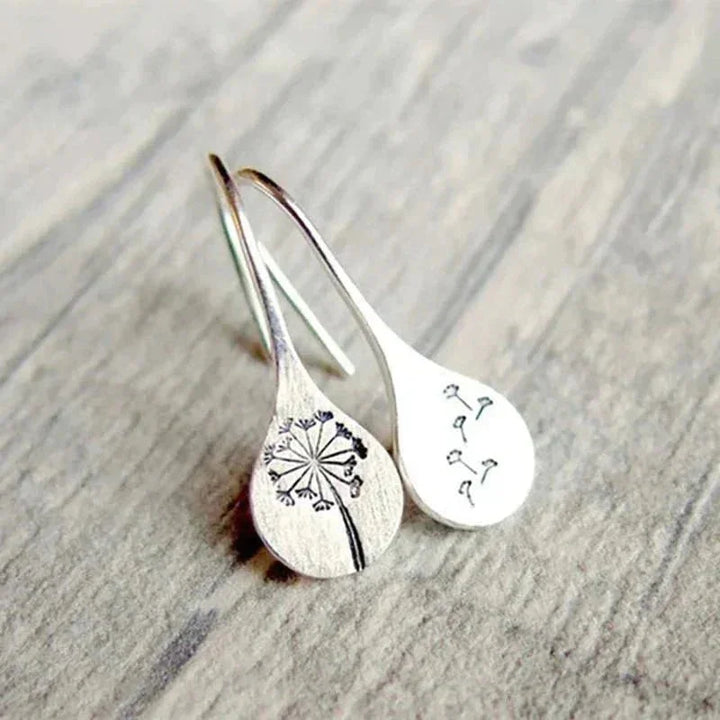 Close-up of women's sterling silver dandelion teardrop dangle earrings. Delicate unique design with real dandelion seeds.