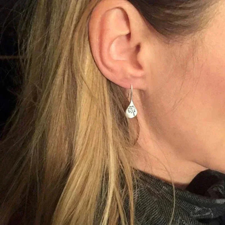 Chic women's sterling silver teardrop dangle earrings featuring a beautiful dandelion design. Elegant & unique gift for her.