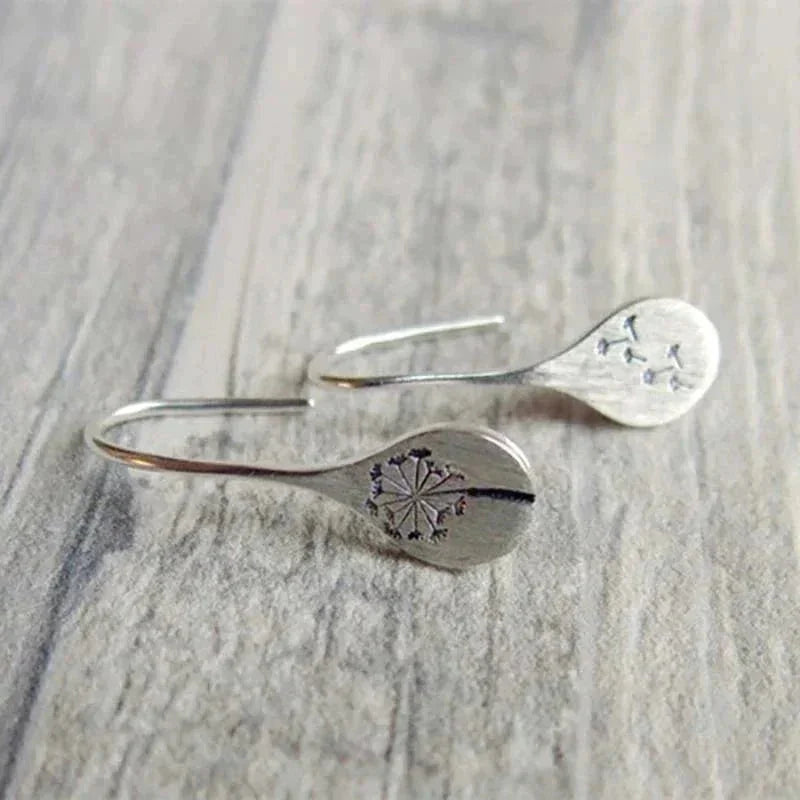 Shimmering sterling silver teardrop dangle earrings for women with intricate dandelion design. Elegant and unique jewelry.