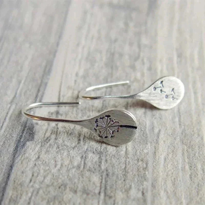 Shimmering sterling silver teardrop dangle earrings for women with intricate dandelion design. Elegant and unique jewelry.