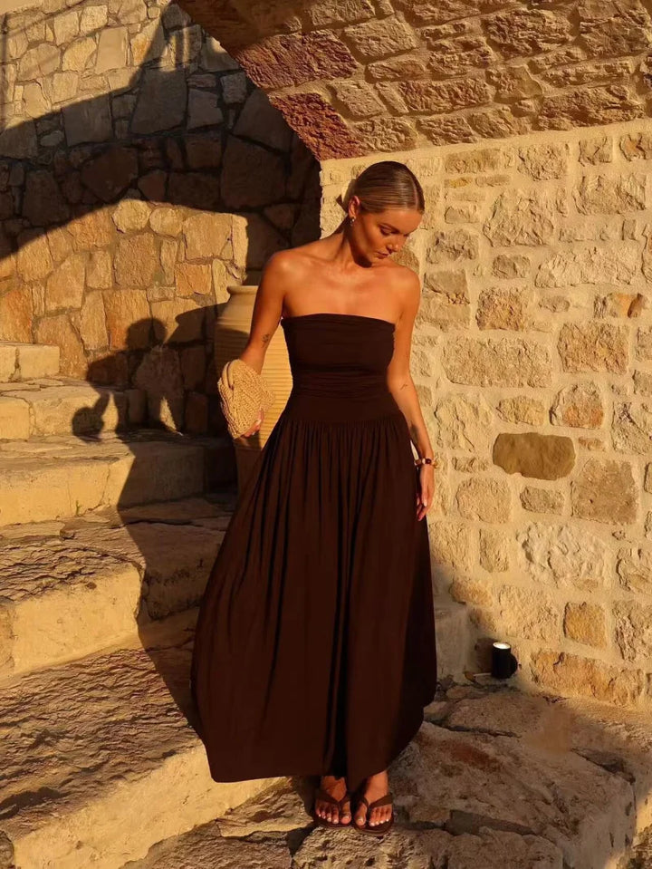 Feminine brown strapless maxi dress with elegant pleats, a stylish choice for women's party wear.