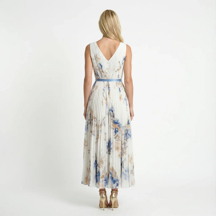 Woman wearing an elegant floral pleated V-neck maxi dress, perfect as a wedding guest outfit.