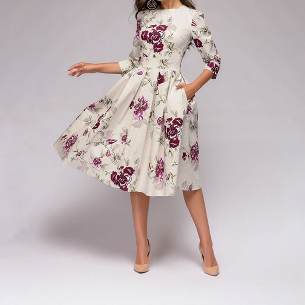Women's A-line dress in white with floral print, 3/4 sleeves and knee-length hem.