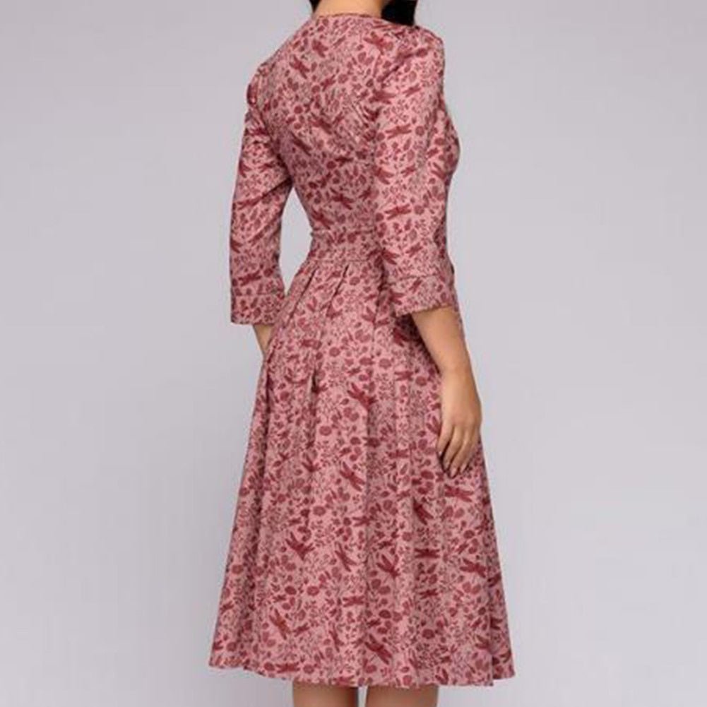 Women's A-line dress in pink with floral print, 3/4 sleeves and knee-length hem.