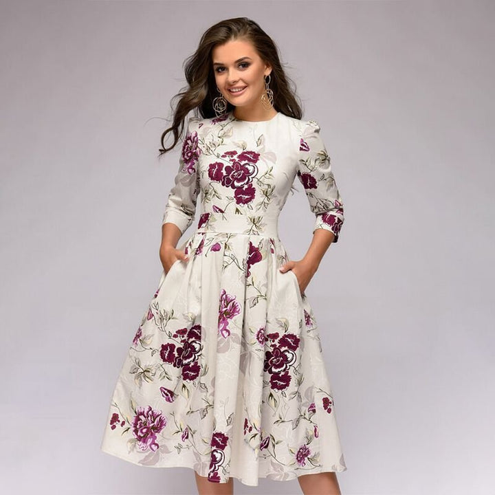 Women's A-line dress in navy blue with floral print, 3/4 sleeves and knee-length hem.