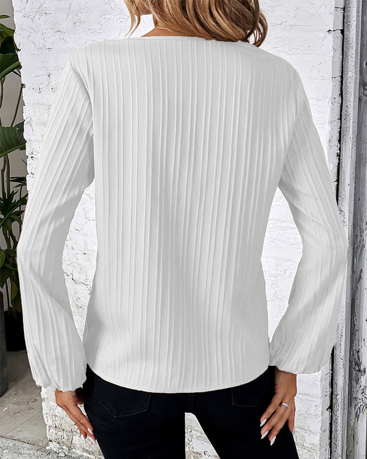 Trendy women's clothing: a solid V-neck blouse with distinctive balloon sleeves, perfect for modern style.