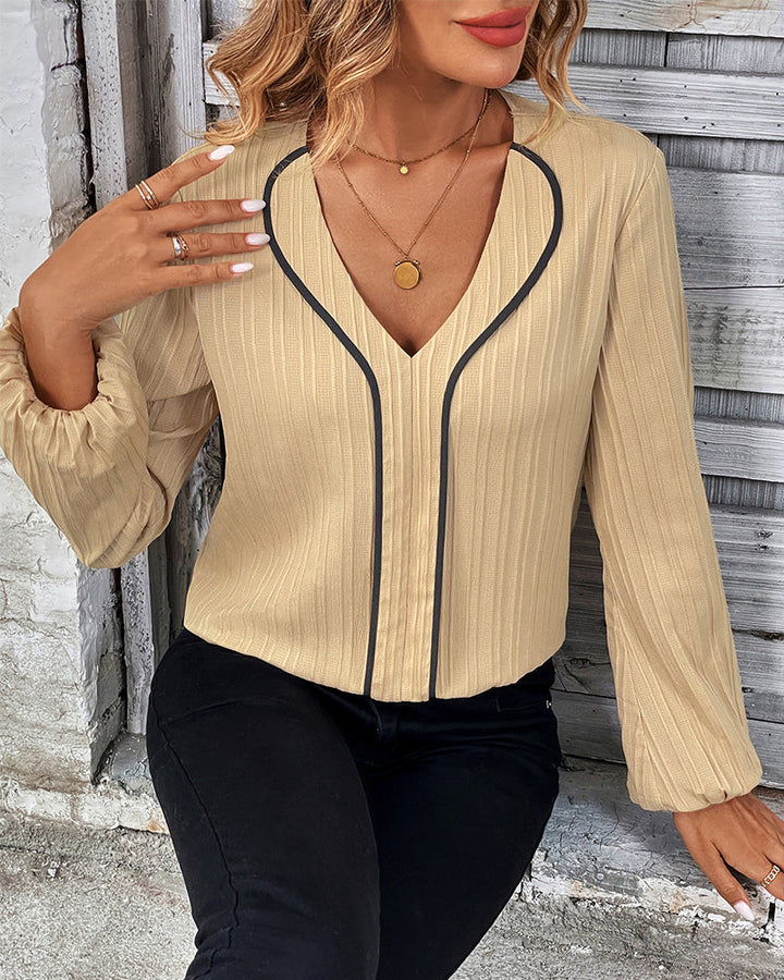 Chic women's V-neck blouse with elegant balloon sleeves. A solid color top for versatile casual & office looks.