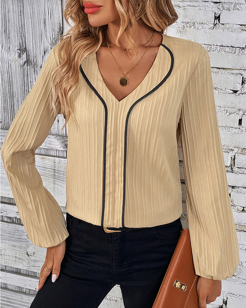 Fashionable women's solid V-neck top with graceful balloon long sleeves, suitable for a sophisticated look.