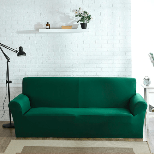 "Emerald green sofa cover on a couch, showcasing its stretchy and durable fabric, perfect for protection and style."