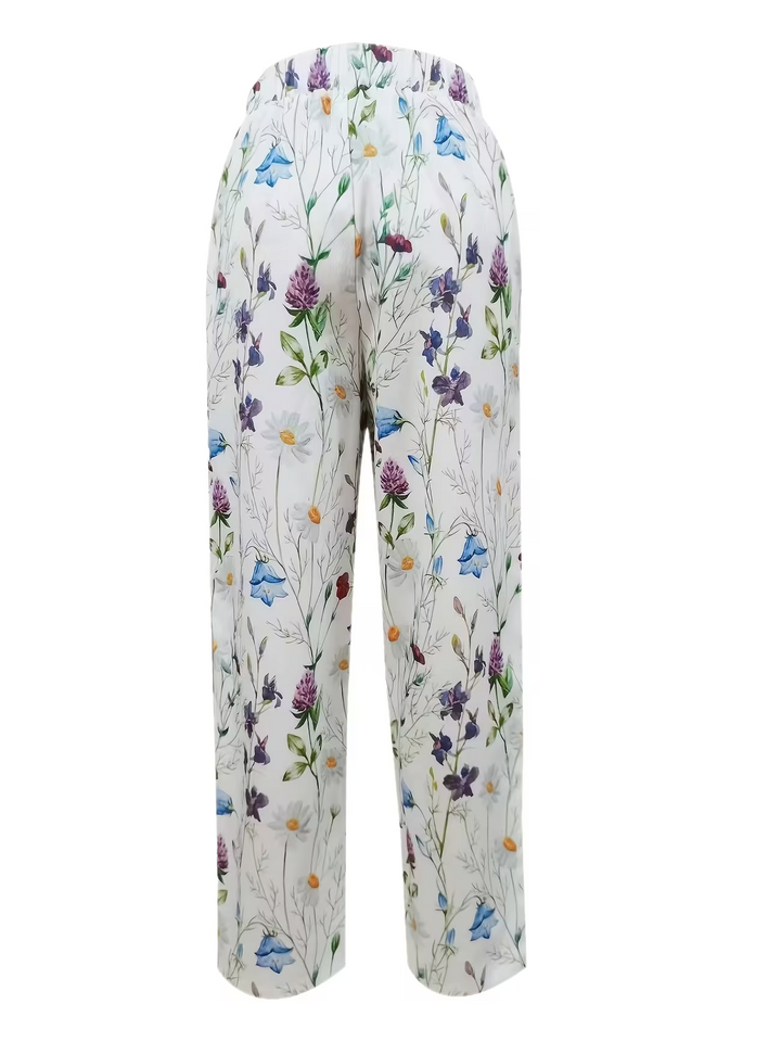 Elegant women's floral print summer trousers. Breathable, relaxed fit white pants, ideal for warm weather and vacation fashion.