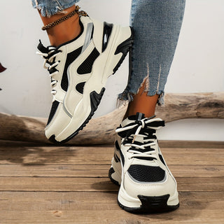 Close-up of women's chunky platform trainers showing contrast panel detail, sturdy sole, and white laces.