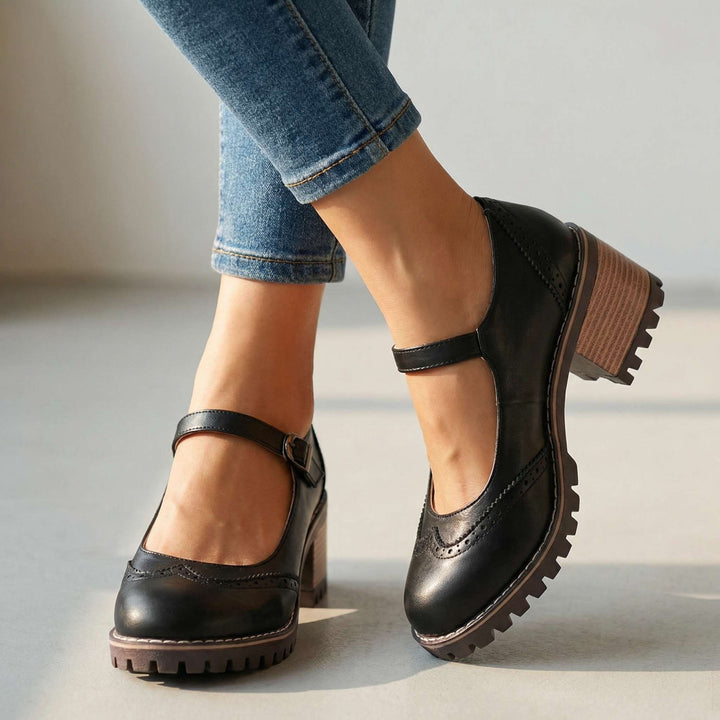 Close-up of classic T-strap & closed-toe details on women's comfort heels. Elegant and supportive design.