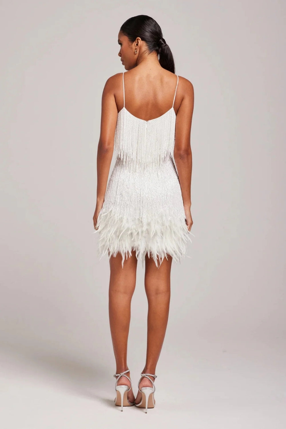 Women's fringe mini dress with feather trim, a glamorous and fitted design for any special occasion.