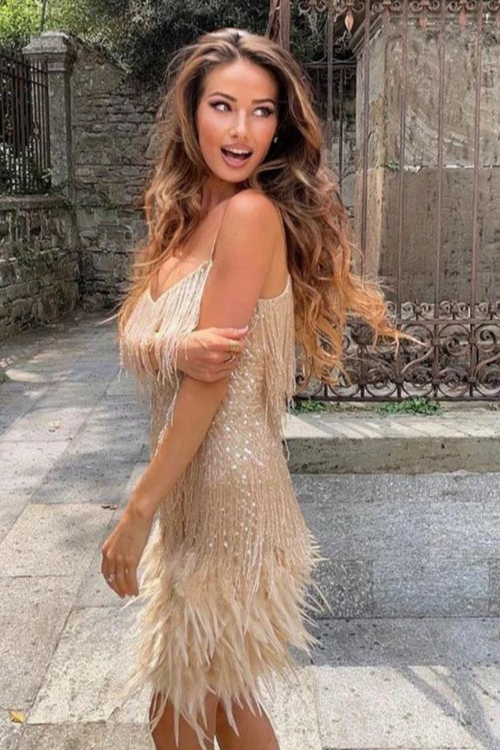 Textured women's mini dress with flowing fringe and soft feather accents, ideal for a glamorous party.