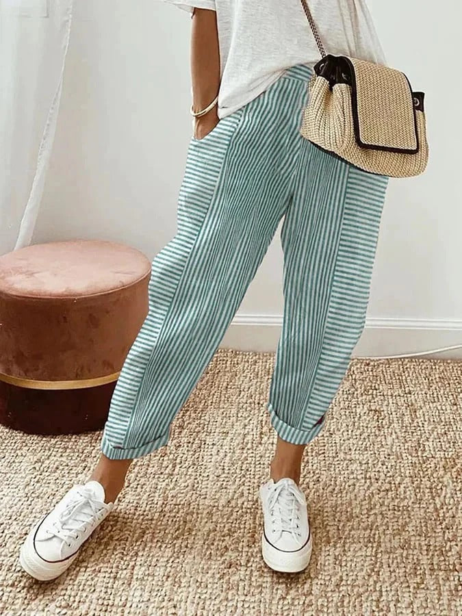 Full-length view of woman wearing effortless relaxed striped summer pants, showcasing their flowy style.