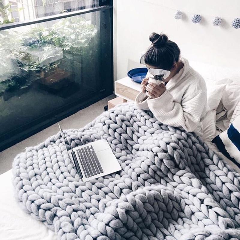 "Handmade chunky knit blanket, super soft texture, vibrant colors draped on furniture, decorative and cozy home accent."