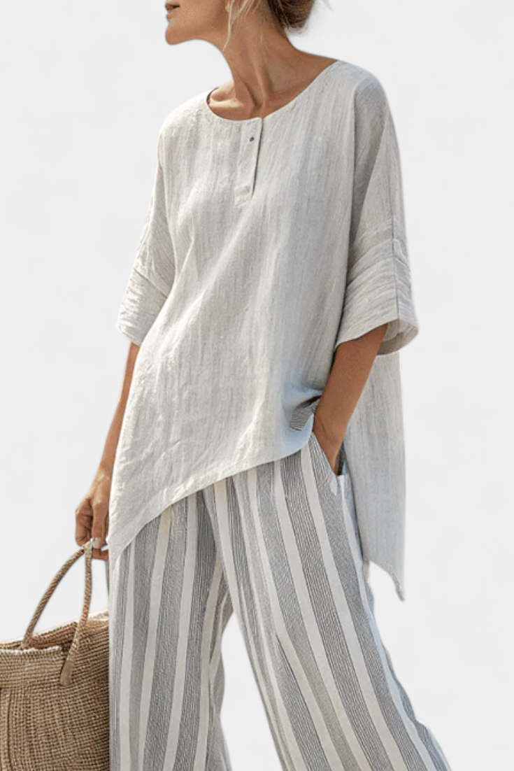 Women's elegant asymmetrical blouse & wide-leg striped pants set. Chic summer fashion, ideal for vacation.