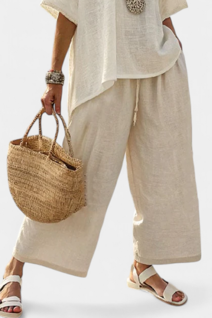Elegant women's white minimalist wide-leg pants and comfortable blouse set, ideal for chic summer fashion & lounge.