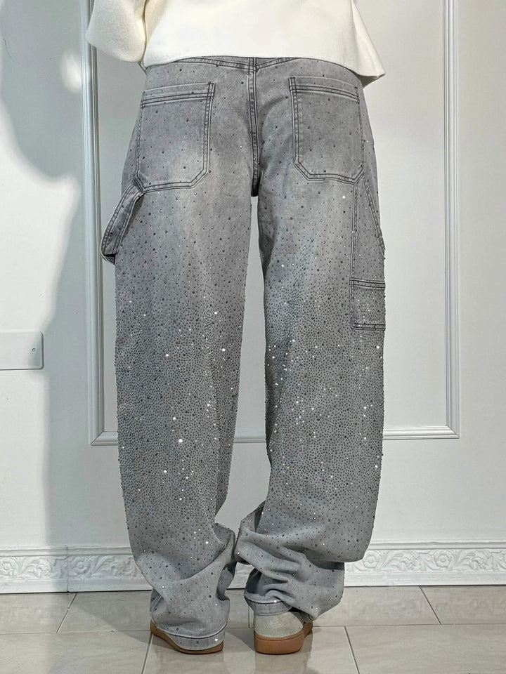 Close-up of dazzling crystal details on elegant women's high-waist straight leg trousers.