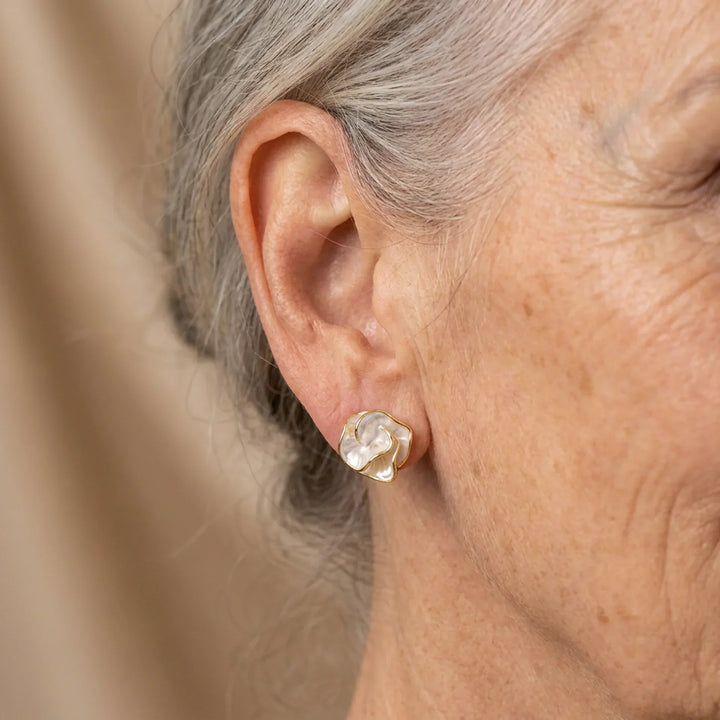 Delicate white pearl and gold-tone flower drop earrings for women. Elegant floral jewelry.