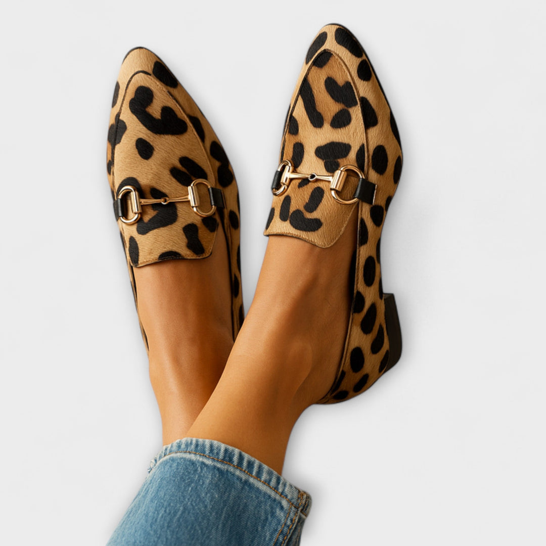 Women's sleek animal print loafers with pointed toe and metallic buckle. Elegant slip-on fashion footwear.