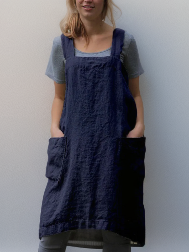 Stylish women's cross-back workwear apron dress, versatile for various tasks with essential pockets.
