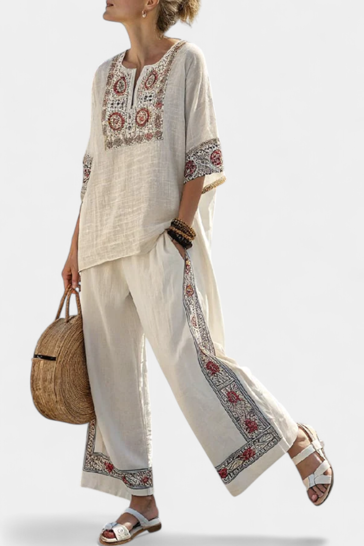 Elegant women's two-piece set featuring a sophisticated embroidered blouse and comfortable wide-leg floral trousers for summer.
