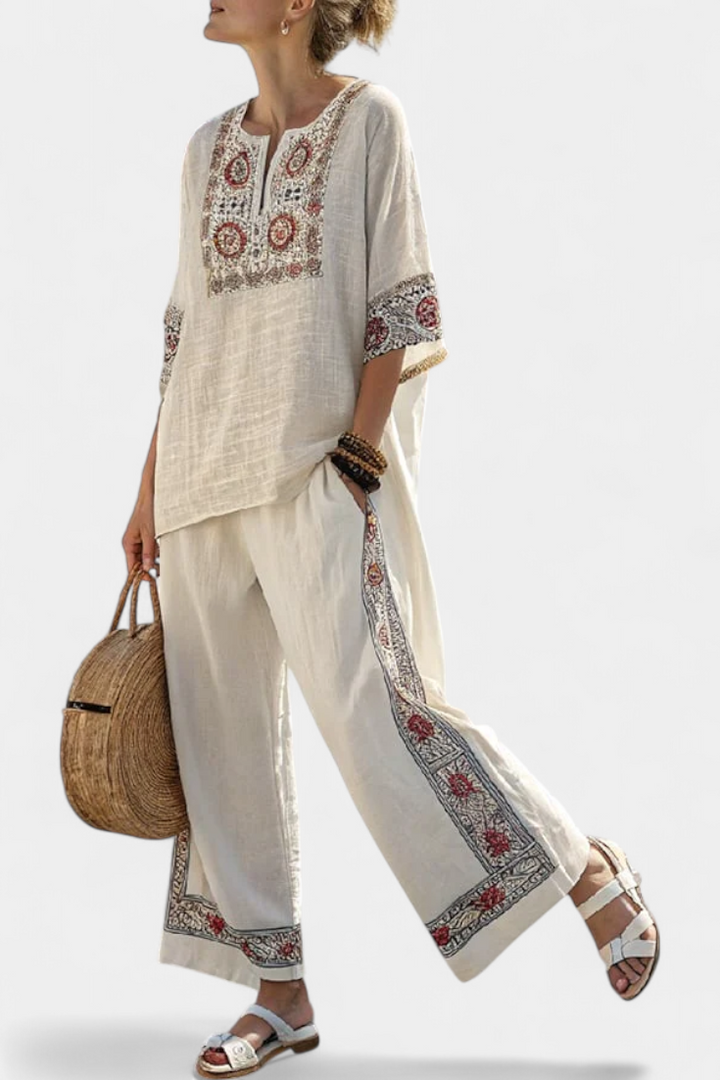 Elegant women's two-piece set featuring a sophisticated embroidered blouse and comfortable wide-leg floral trousers for summer.