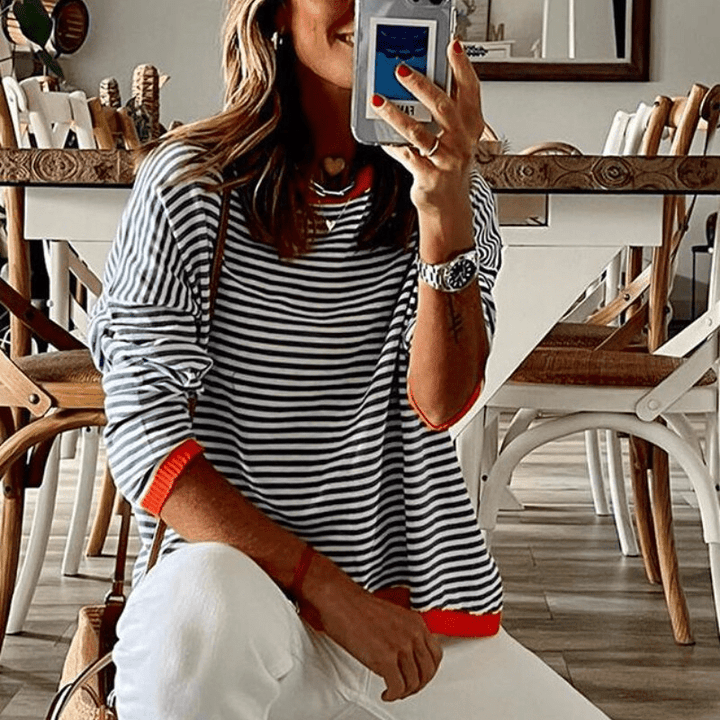 Chic women's blue striped pullover sweater with vibrant orange trim, ideal for comfortable fall and winter casual wear.