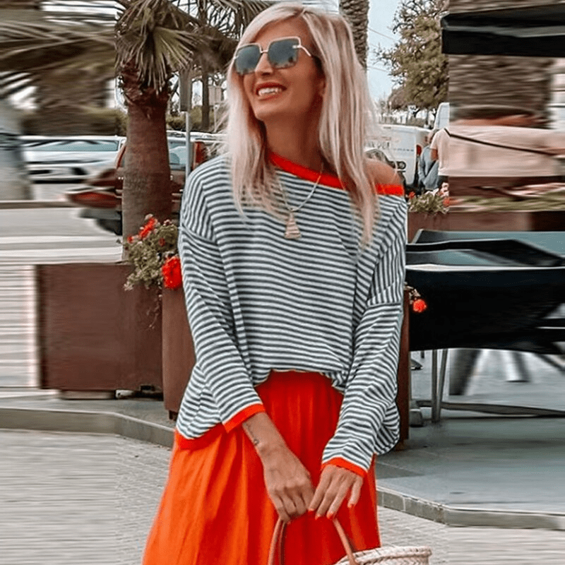 Elegant women's long-sleeve blue striped sweater featuring stylish orange trim, perfect for fall and winter fashion.