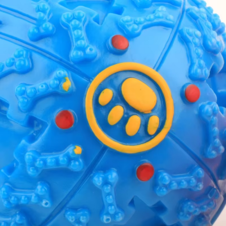 Close-up of a dog interacting with a squeaky ball that dispenses treats.