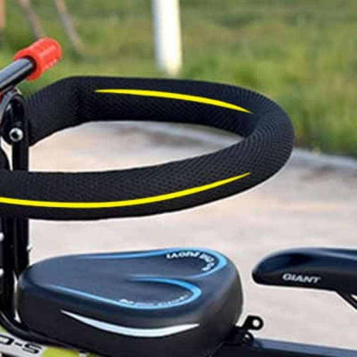 "Kids child bike seat in vibrant red and black with safety harness and padded seat, designed for adult bicycles."