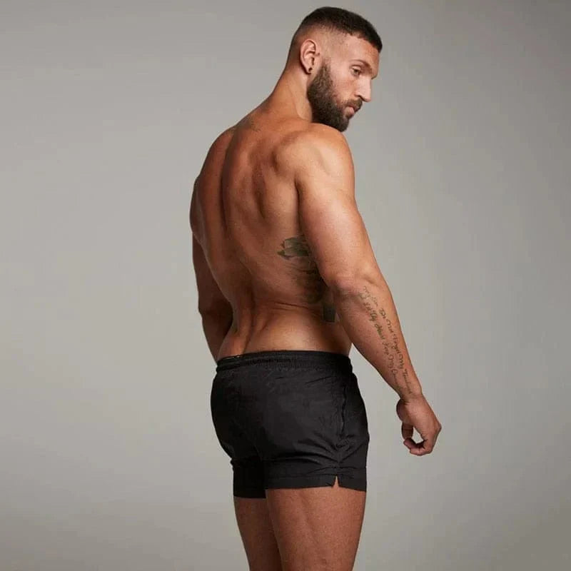 Stylish men's short swim trunks, perfect for summer beach vacations. Athletic fit swimwear with pocket.