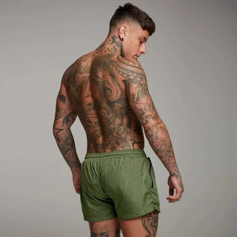 Athletic men's short swim trunks for active summer beach & pool wear. Quick-dry swimwear with pocket.