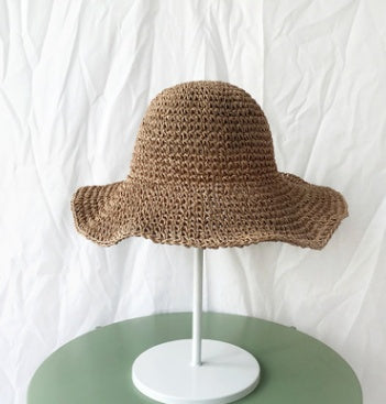 Women's straw bucket hat, wide brim design for beach & summer sun protection. Crochet style.