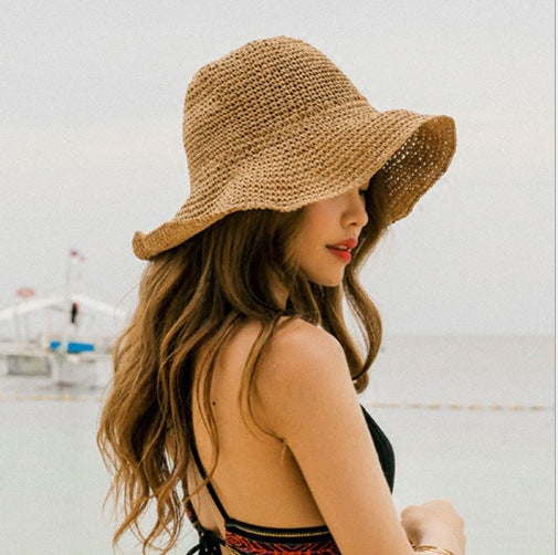 Women's wide brim straw bucket hat, perfect for summer beachwear & sun protection. Stylish crochet design.