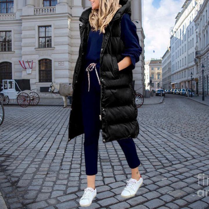 Warm padded women's long gilet with a protective hood, ideal sleeveless jacket for cold weather outerwear.