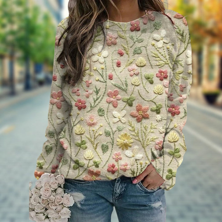 Close-up of a women's spring sweater with delicate floral embroidery. Lightweight crewneck knitwear for chic casual outfits.