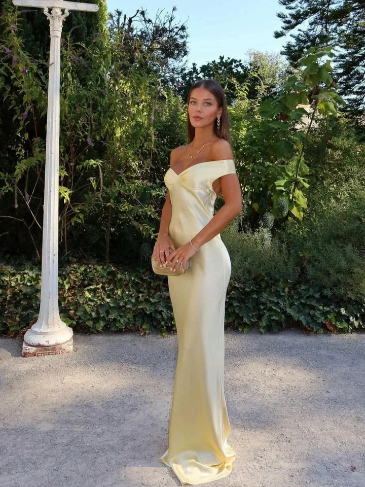 Elegant yellow off-shoulder maxi dress with a matching clutch, ideal for women's evening or party wear.