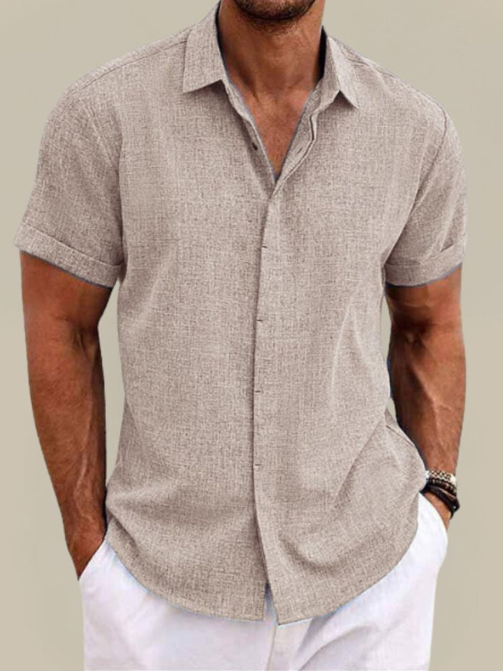 Model wearing a men's breathable lightweight short sleeve button-up shirt, styled for summer.