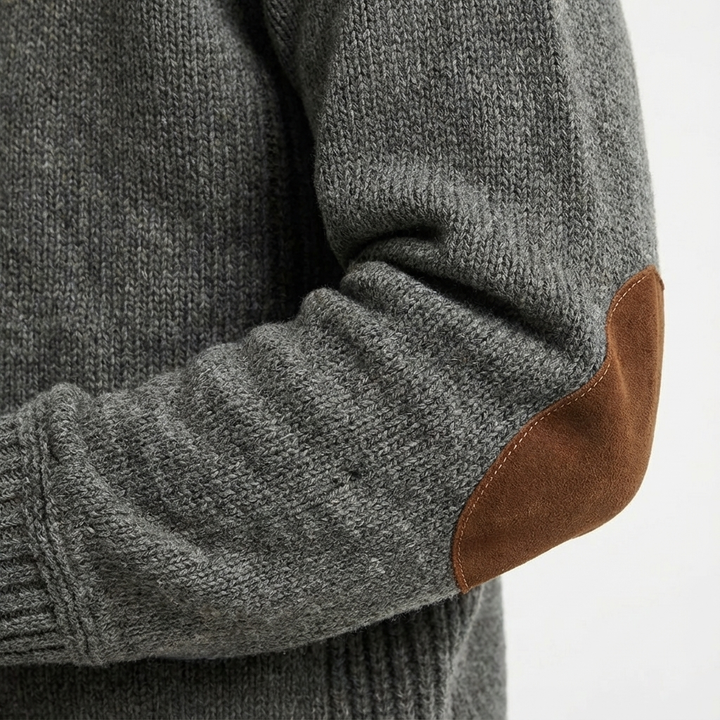 Close-up of a men's classic sweater showing the textured knit and detailed corduroy elbow patches.