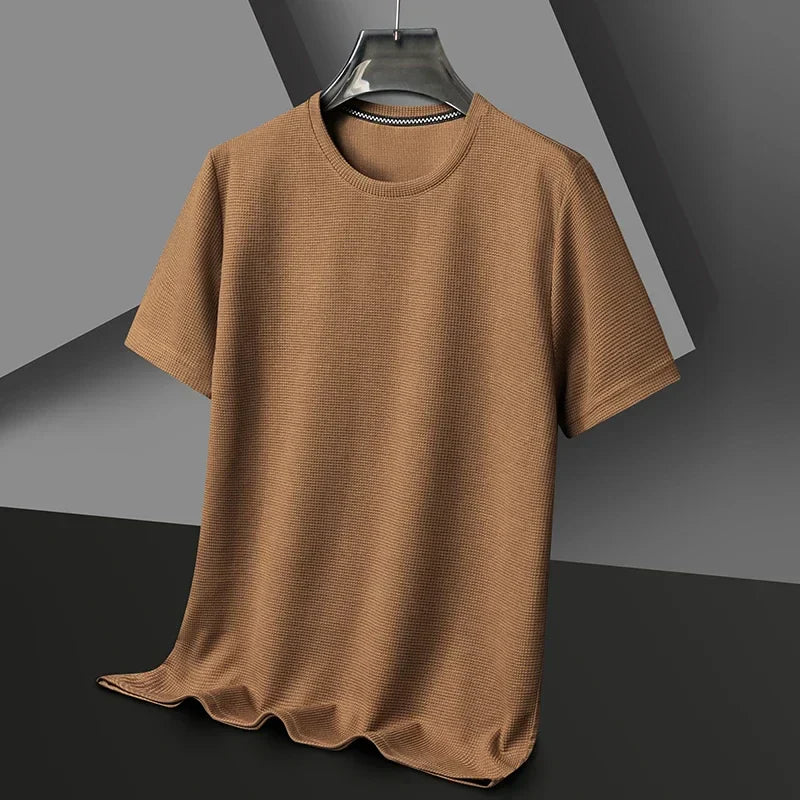 Close-up of a men's modern waffle knit t-shirt, showing the comfortable texture. Crew neck, short sleeve, versatile style.