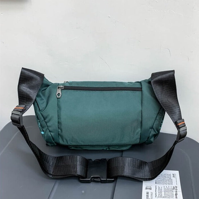 Front view: Men's water-resistant sling bag, black nylon. Multi-way travel pack, ideal for waist or crossbody.