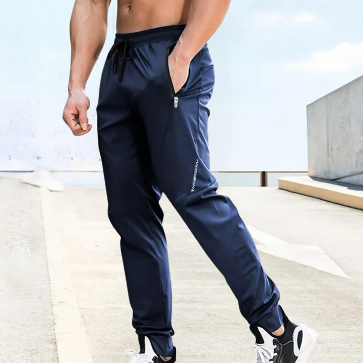 Comfortable men's performance training trousers in a dark color. Ideal for sports, running, gym, and active lifestyle.