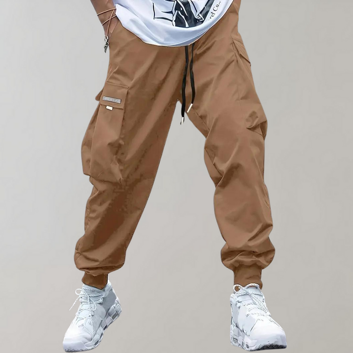 Brown men's relaxed cargo trousers featuring a practical drawstring waist and multiple utility pockets.