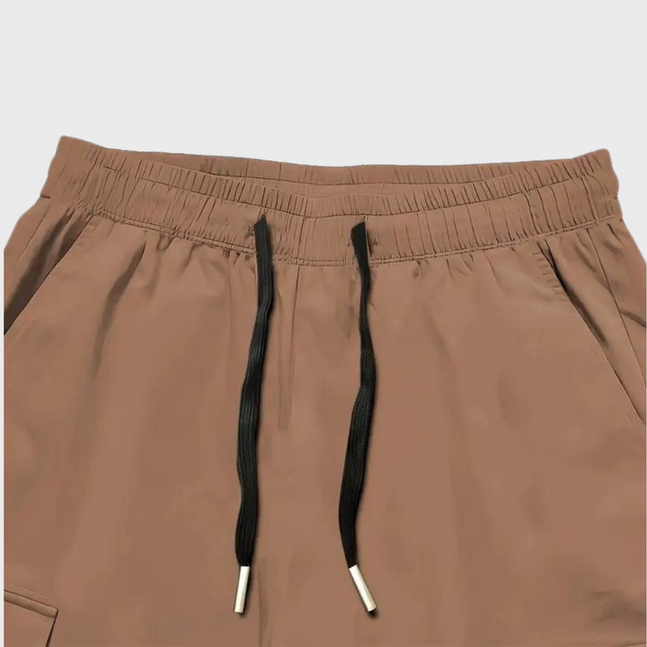 Relaxed fit men's utility cargo trousers with an adjustable drawstring waist, offering comfort and style.