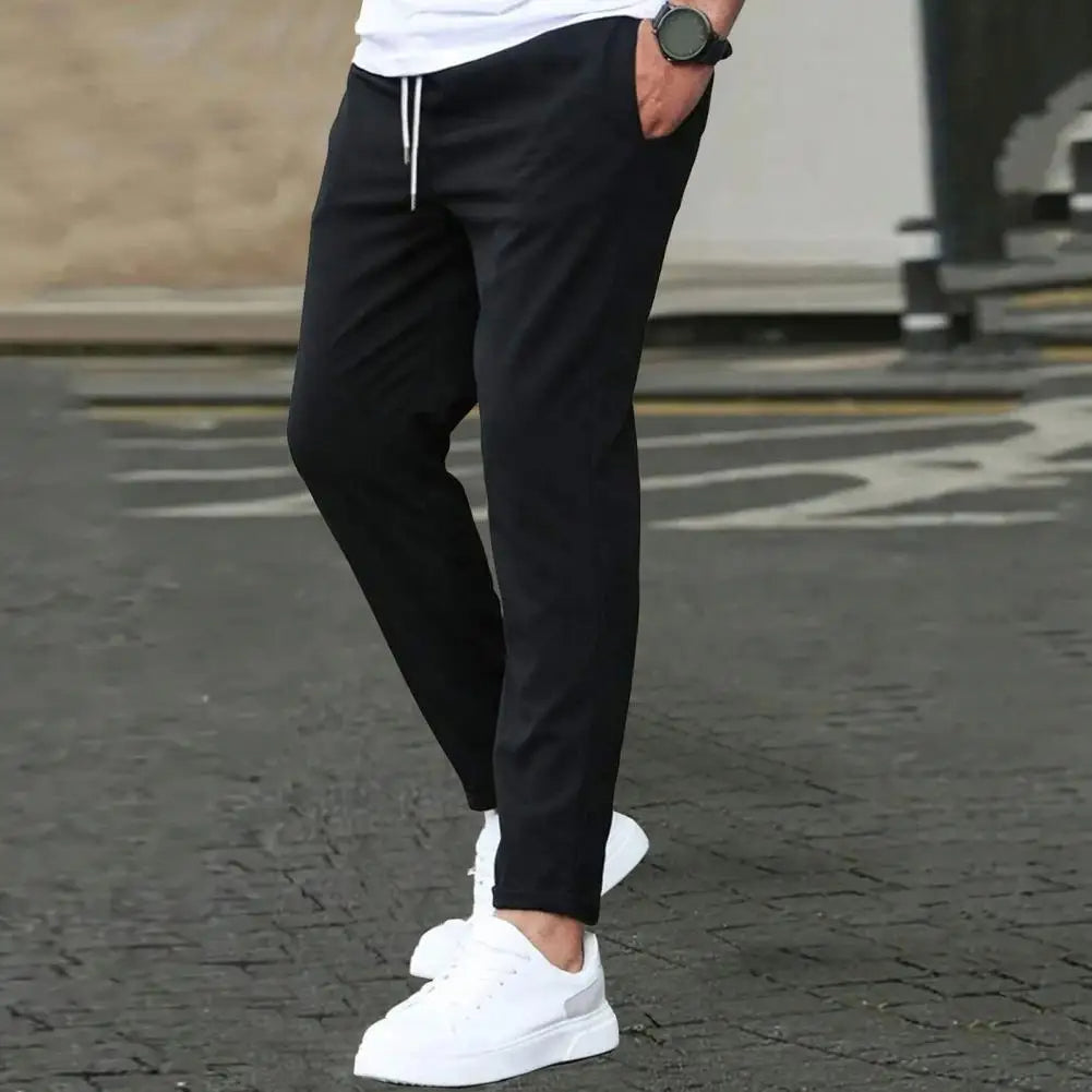 Comfortable polyester men's track pants. Sporty design, elastic waist, and practical pockets for daily casual wear.