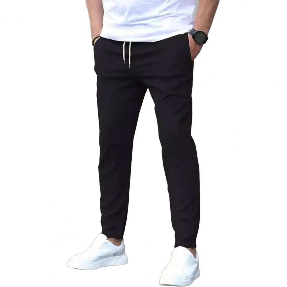 Close-up of men's sporty joggers, showing elastic waist with drawstring and practical side pockets. Great for active style.