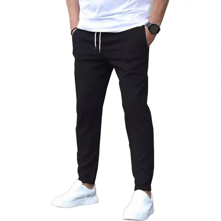 Close-up of men's sporty joggers, showing elastic waist with drawstring and practical side pockets. Great for active style.