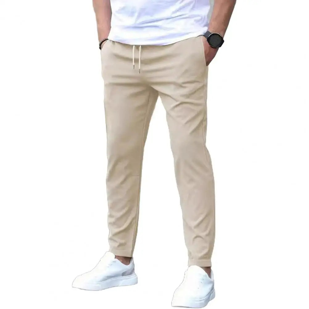 Man wearing sporty men's joggers, showcasing athletic fit, elastic waist, and pockets for activewear.